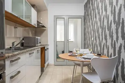 a kitchen with a table and chairs in a kitchen at Fifth Apartment by Homie in Funchal