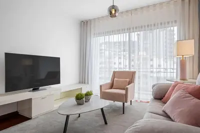 a living room with a couch and a chair and a television at Fifth Apartment by Homie in Funchal
