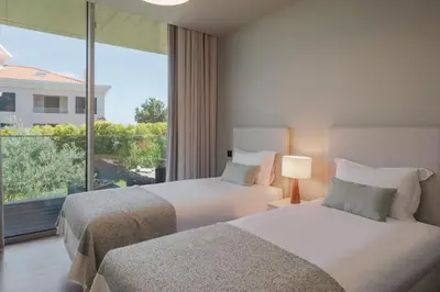two beds in a hotel room with a large window at Savoy Residence Casa Branca II by An Island Apart in Funchal
