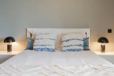 a bedroom with a white bed with blue and white pillows at Savoy Residence Casa Branca II by An Island Apart in Funchal