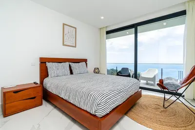 a bedroom with a bed and a large window at Villa Rocha in Arco da Calheta in Arco da Calheta