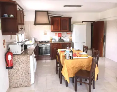 a kitchen with a table with chairs and a refrigerator at Casa Manuel J. J. M -Alfambras, Aljezur - Quiet Country House in Aljezur
