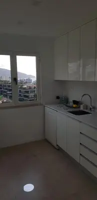a kitchen with white cabinets and a large window at The Sunrise of your Dreams with Total Ocean View with New Modern Kitchens 75 m2 in Funchal