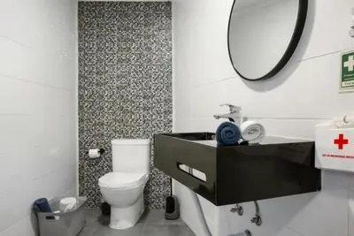 a bathroom with a sink and a mirror and a toilet at Casa dos avós in São Vicente