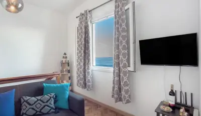 a living room with a window with a view of the ocean at Casa dos avós in São Vicente