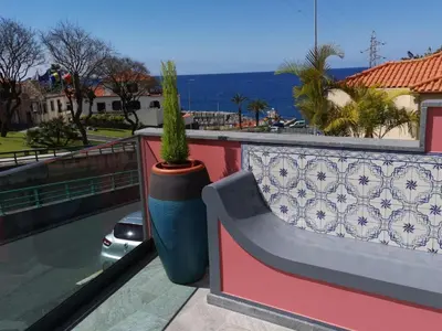 a bench and a potted plant on a balcony at Chalé Esmeralda - Charming Studios in Calheta Beach in Calheta