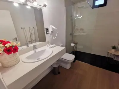 a bathroom with a sink and a toilet and a mirror at Chalé Esmeralda - Charming Studios in Calheta Beach in Calheta