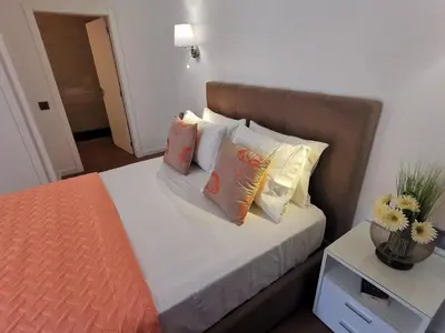 a bedroom with a bed with pillows and a table at Chalé Esmeralda - Charming Studios in Calheta Beach in Calheta