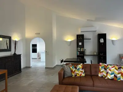 a living room with a couch and a table at Casa do Poço in Burgau
