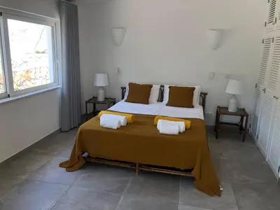a bedroom with a large bed with two towels on it at Casa do Poço in Burgau