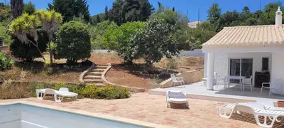 a house with a patio with chairs and a garden at Casa do Poço in Burgau