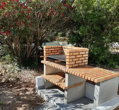 a wooden bench sitting in a garden with flowers at Casa do Poço in Burgau