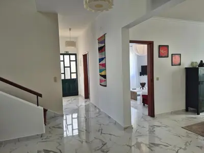 a living room with a marble floor and a hallway at Villa Vista Norte in Porto Moniz