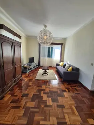 a living room with a couch and a chandelier at Villa Vista Norte in Porto Moniz