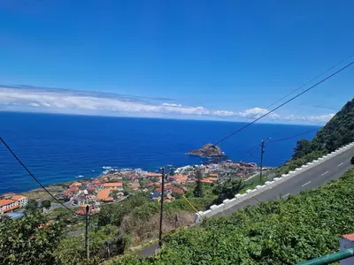 a road on a hill next to the ocean at Villa Vista Norte in Porto Moniz
