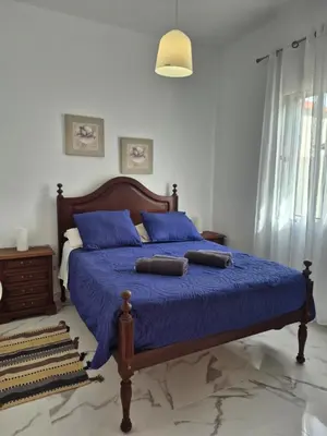 a bedroom with a blue bed with blue pillows at Villa Vista Norte in Porto Moniz
