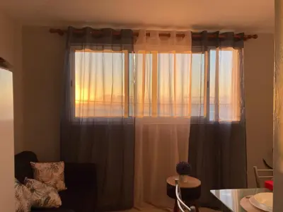 a living room with a large window with curtains at Faria's House in Ponta Delgada