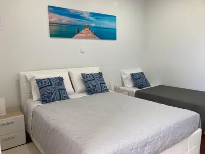a bedroom with two beds and a picture on the wall at Faria's House in Ponta Delgada