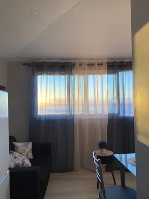 a living room with a couch and a table and a window at Faria's House in Ponta Delgada