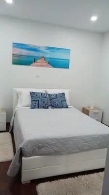 a bedroom with a bed with a painting on the wall at Faria's House in Ponta Delgada