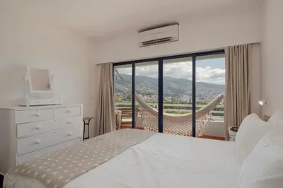 a bedroom with a bed and a large window at Vista Mar I by An Island Apart in Funchal