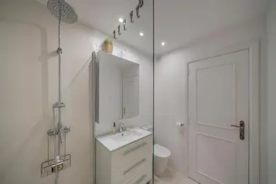 a white bathroom with a sink and a mirror at Vista Mar I by An Island Apart in Funchal