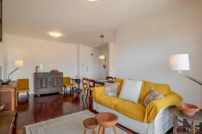 a living room with a yellow couch and a table at Vista Mar I by An Island Apart in Funchal