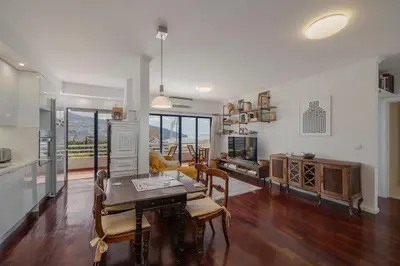 a kitchen and living room with a table and chairs at Vista Mar I by An Island Apart in Funchal