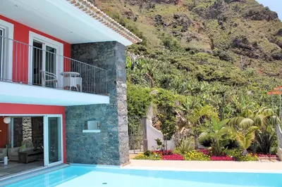 a house with a swimming pool next to a mountain at Beautiful Calheta Villa Villa Do Mar Iii 3 Bedrooms Infinity Pool in Arco da Calheta