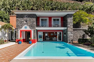 a villa with a swimming pool in front of a house at Beautiful Calheta Villa Villa Do Mar Iii 3 Bedrooms Infinity Pool in Arco da Calheta