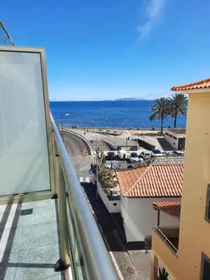 a view of the ocean from the balcony of a building at Sunny Beach Machico Apartment by Holiday Rental Madeira in Machico