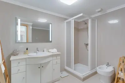 a bathroom with a shower and a sink and a toilet at Sunny Beach Machico Apartment by Holiday Rental Madeira in Machico