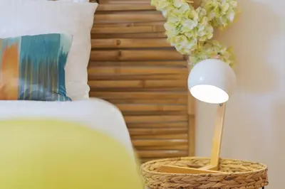 a lamp in a basket next to a bed at Sunny Beach Machico Apartment by Holiday Rental Madeira in Machico