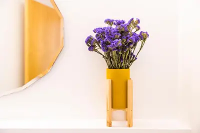 a yellow vase with purple flowers sitting on a shelf at Casa Da Avo Clementina Nº32 in Funchal