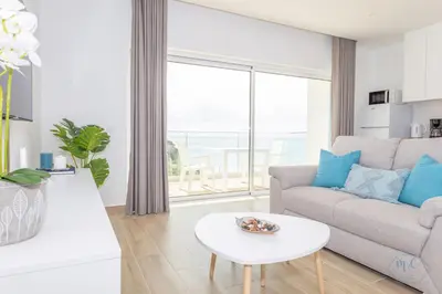 a living room with a couch and a table at MC Suites Burgau with amazing front sea view in Burgau