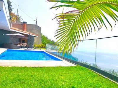 a swimming pool in front of a house at Villa Sol e Mar in Ribeira Brava