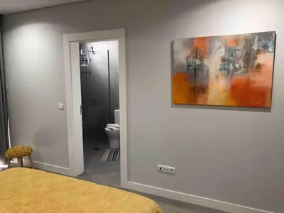 a bedroom with a bed and a painting on the wall at Villa Sol e Mar in Ribeira Brava