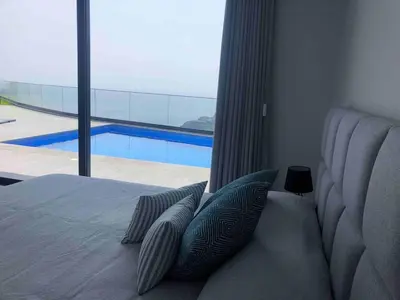 a bedroom with a bed with a view of a pool at Villa Sol e Mar in Ribeira Brava