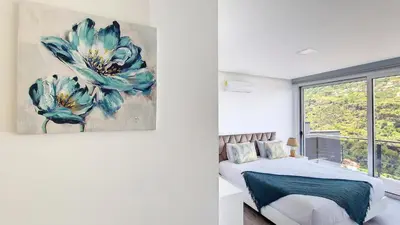 a bedroom with a large blue flower painting on the wall at Villa Oceânica by LovelyStay in Ribeira Brava