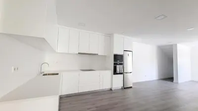 a white kitchen with white cabinets and a wooden floor at Villa Oceânica by LovelyStay in Ribeira Brava