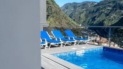 a balcony with chairs and a swimming pool with mountains at Villa Oceânica by LovelyStay in Ribeira Brava
