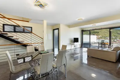 a dining room and living room with a table and chairs at Casa da Pontinha in Machico