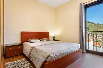 a bedroom with a bed and a large window at Casa da Pontinha in Machico