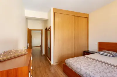 a bedroom with a bed and a wooden cabinet at Casa da Pontinha in Machico