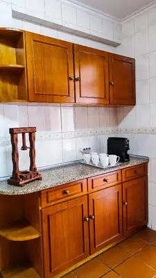 a kitchen with wooden cabinets and a counter top at Casa Gina, with views to Funchal Bay in Funchal