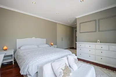 a bedroom with a large white bed and a dresser at Barreiros Balcony in Funchal