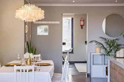 a dining room with a white table and a chandelier at Barreiros Balcony in Funchal