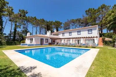 a villa with a swimming pool in front of a house at Casa Nook Arrifana in Aljezur