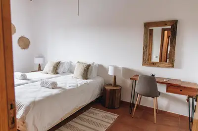 two beds in a room with a mirror and a desk at Casa Nook Arrifana in Aljezur