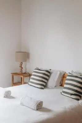 a white bed with two pillows on top of it at Casa Nook Arrifana in Aljezur